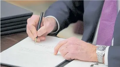  ?? AP ?? En foco. Imagen del momento en que Biden firma ante la prensa de una de las medidas sobre el Covid.