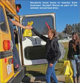  ??  ?? Students hand items to teacher Kate Andrews' Kendell Wiens as part of the schools’ annual food drive.