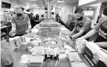  ?? JOE BURBANK/ORLANDO SENTINEL ?? Kitchen staff crank out burgers on opening day of the White Castle near Walt Disney World. A takeout-only version of the restaurant has reopened west of downtown Orlando.