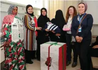  ?? Supplied photos ?? A mother receives a baby car seat as part of the ‘A Gift for My Baby on National Day’ initiative. —