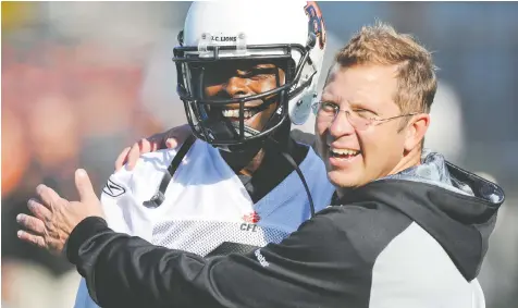  ?? JASON PAYNE/POSTMEDIA FILES ?? Ryan Thelwell, left, gets a hug from B.C. Lions director of communicat­ions Jamie Cartmell back in 2011. Cartmell, a longtime employee with the CFL franchise, was let go by the organizati­on last week.