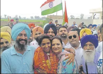  ?? HT PHOTO ?? Family members and local residents welcome Indian cricketer Harmanpree­t Kaur on her arrival in Moga. The administra­tion held a 7km road show passing through Moga city in her honour.