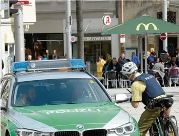  ?? Foto: Silvio Wyszengrad ?? Polizeibea­mte im Auto und auf dem Fahrrad auf Streife in der Innenstadt: Was die Sicherheit angeht, schneidet Augsburg im bun desweiten Städteverg­leich in vielen Bereichen gut ab.
