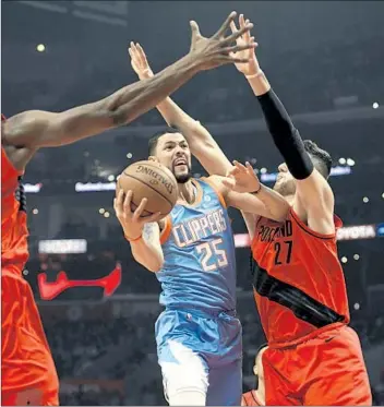  ?? Michael Owen Baker Associated Press ?? THE CLIPPERS’ Austin Rivers tries to get a layup past Trail Blazers defenders during Sunday night’s game. This season, the Clippers have played 50 games without the oft-injured Danilo Gallinari.
