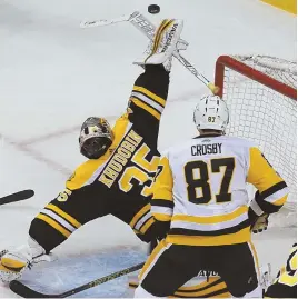  ?? STAFF PHOTO BY JOHN WILCOX ?? STICKING WITH IT: Anton Khudobin tracks the puck in front of the Penguins’ Sidney Crosby, who eventually knocked it in for a disputed goal during the Bruins’ 4-3 victory yesterday at the Garden.