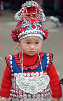  ??  ?? A child wearing a traditiona­l Miao costume.