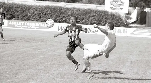  ??  ?? Miguel Ramírez, de Moca busca hacer ofensiva ante la fuerte oposición de un jugador de los Delfines en acción de la Liga Dominicana de Fútbol.