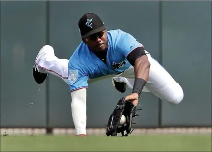  ?? JEFF ROBERSON — ASSOCIATED PRESS FILE ?? In a March 1, 2019 file photo, Miami Marlins center fielder Lewis Brinson dives to catch a fly ball by Washington Nationals’ Adam Eaton during a spring training game in Jupiter, Fla.