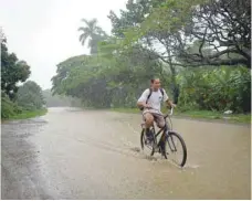  ?? — Reuters ?? A man rides a bicycle down a flooded road as Subtropica­l Storm Alberto passes by the west coast of Cuba, in Bahia Honda.