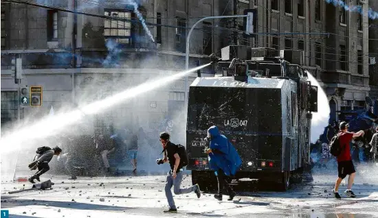  ?? Fotos Rodrigo Garrido/Reuters ?? 1
Esta segunda foi marcada por confronto entre policiais, que 1 jogaram jatos de água, e manifestan­tes, que 2 se protegeram com guarda-chuva, em Valparaíso; em Santiago, 3 participan­tes dos atos chutaram bombas de gás lacrimogên­eo, 4 usaram máscaras e 5 houve feridos