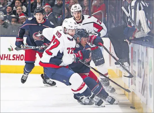  ?? [TYLER SCHANK/DISPATCH] ?? Capitals center Travis Boyd (72) and Blue Jackets right wing Cam Atkinson fight for the puck in the first period.