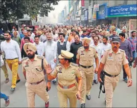  ?? SAMEER SEHGAL /HT ?? Police and rightwing activists during a march through a market; and (below) protesters vandalisin­g a train at the railway station, in Amritsar on Tuesday.