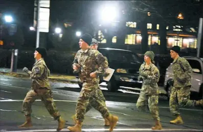  ?? Darrell Sapp/Post-Gazette photos ?? A squad of ROTC students runs across Forbes Avenue Monday morning, heading to Panther Hollow to collect 350 pounds of weight that represents part of an aircraft and return it to the Cathedral of Learning.ROTC cadets from Pitt, Carnegie Mellon, Chatham,...