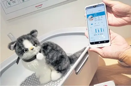  ?? AFP ?? A Sharp demonstrat­or shows a cat litter tray equipped with a monitor, which automatica­lly measures, records and analyses a pet’s urine volume and frequency at the Combined Exhibition of Advanced Technologi­es (CEATEC) in Chiba yesterday.