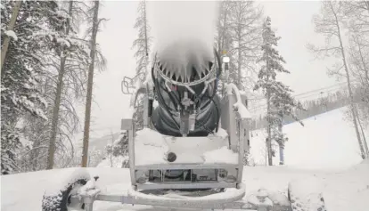  ?? BRITTANY PETERSON/AP ?? A machine blows snow at Vail Mountain Resort, Wednesday, Dec. 29, 2021, in Vail, Colo. Newer snowmaking technology is allowing ski areas to be more efficient with energy and water use as climate change continues to threaten snowpack levels.