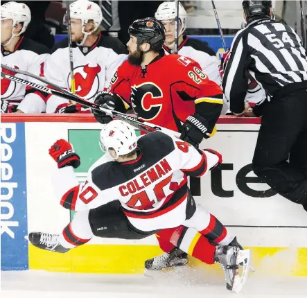  ?? LEAH HENNEL ?? New Jersey Devils forward Blake Coleman collides with Flames defenceman Deryk Engelland Friday at the Scotiabank Saddledome. The visiting Devils took advantage of a slow start by the home side to upset Calgary 2-1.