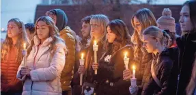  ?? SARAH A. MILLER/AP ?? Boise State University students, along with people who knew the four University of Idaho students who were found killed in Moscow, Idaho, pay their respects at a vigil held in front of a statue on the Boise State campus.