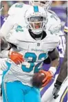  ?? BRUCE KLUCKHOHN/AP ?? Miami running back Kenyan Drake celebrates after scoring against Minnesota on Thursday.