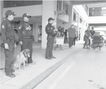  ?? JOY TORREJOS ?? Members of the Special Operations Unit-K9 and Aviation Security Group personnel augment security at the Mactan-Cebu Internatio­nal Airport ahead of the ASEAN ministeria­l meetings in April.