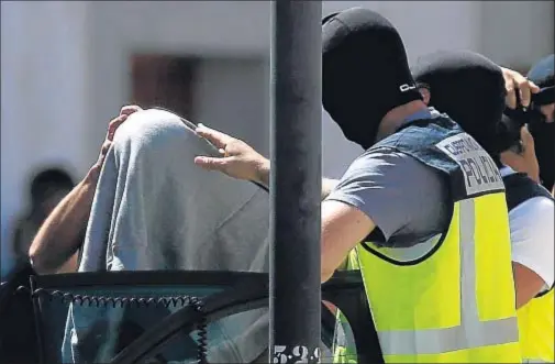  ?? SERGIO PEREZ / REUTERS ?? Los agentes introducen a Achriaa en el coche policial tras el registro efectuado el martes en su casa y el locutorio que llevaba