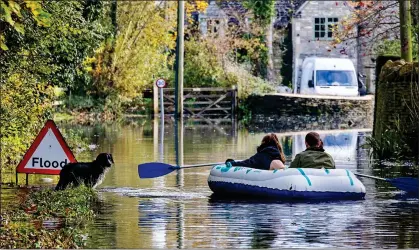  ??  ?? DOGGY PADDLE: Local residents ditched their cars for dinghies in the Cotswolds village of Cerney Wick