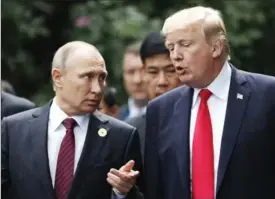  ?? JORGE SILVA, THE ASSOCIATED PRESS ?? U.S. President Donald Trump and Russia’s President Vladimir Putin talk during the family photo session at the APEC Summit in Danang, Vietnam.
