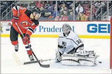  ?? [BILL KOSTROUN/THE ASSOCIATED PRESS] ?? New Jersey’s Taylor Hall slides the puck past Los Angeles goalie Jonathan Quick during Tuesday’s game. LIGHTNING 3, BLUES 0: