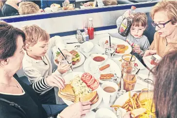  ??  ?? Clockwise from bottom left, Mary Ferdschnei­der; her 4-year-old twins, Logan and Gabi Ferdschnei­der; great-aunt Marlene Zucker; and grandmothe­r Roxanne Ferdschnei­der, dine at Burger Heaven.