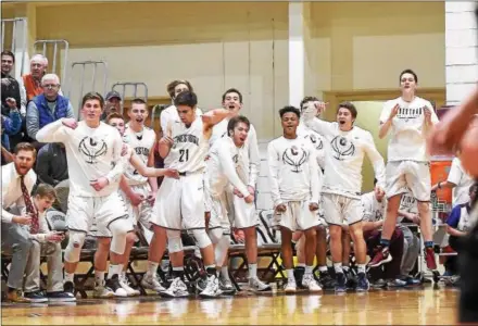  ?? PETE BANNAN — DIGITAL FIRST MEDIA ?? The Conestoga bench celebrates a basket in the closing seconds of the first half Tuesday night against Lower Merion. The Pioneers went on to win 77-57 to advance to the District 1 Class 6A quarterfin­als.