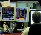  ??  ?? Un operatore di Borsa al desk delle contrattaz­ioni