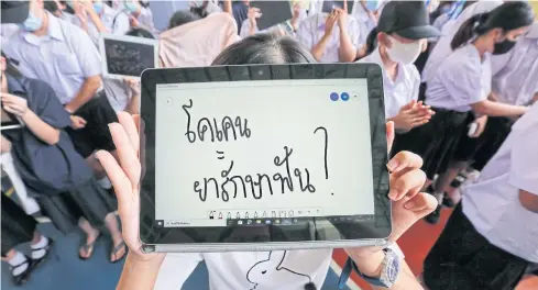  ?? PATTARAPON­G CHATPATTAR­ASILL ?? A protesting Triam Udom Suksa School student displays a message reading ‘cocaine = dental medicine?’ to ridicule the high-profile hit-and-run case involving Red Bull scion Vorayuth Yoovidhya during the anti-government rally at their campus in Bangkok’s Pathumwan district yesterday.