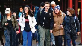  ??  ?? Students from Fiorello H LaGuardia High School of Music & Art and Performing Arts cross the street on Tuesday after getting out of school for the day. LaGuardia, with a predominan­tly white or Asian student population, is one of many New York City...