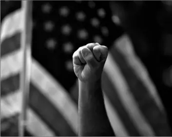  ?? AP Photo/Jae C. Hong ?? In this June 1 file photo a demonstrat­or raises his fist during a protest over the death of George Floyd, in Anaheim, Calif.