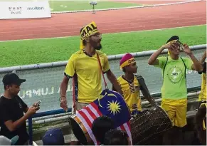  ??  ?? Drumming up support: Gurmesh (second left) and Shaunvinde­r playing the dhol during a SEA Games match in Kuala Lumpur.