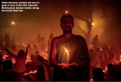  ?? ?? Hindu devotees worship and pray to gods in front of Shri Shri Lokenath Brahmachar­i Ashram temple during the Kartik Brati fast