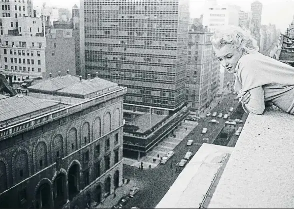  ?? ED FEINGERSH/MICHAEL OCHS ARCHIVES/GETTY IMAGES ?? Marilyn Monroe contempla Park Avenue desde la terraza de su suite en el Hotel Ambassador de Nueva York, en marzo de 1955