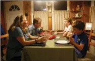  ?? AP PHOTO/MARTHA IRVINE ?? From left, Barb Hailey eats dinner with her husband Allen and sons Everett, 15, and Henry, 10, in Chicago. Mealtime is a screen-free zone in their household.