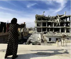  ?? AFP ?? A Syrian hangs out her washing yesterday as residents start to return to the ruins of Raqqa to rebuild their lives