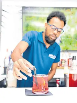  ?? BY GLADSTONE TAYLOR/MULTIMEDIA PHOTO EDITOR PHOTOS ?? Bartender extraordin­aire Nickary Penn serves up this Chill Ting.