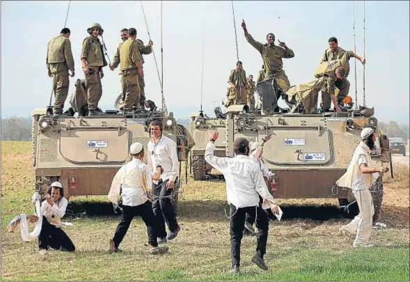  ?? CRISTOPHER FURLONG / GETTY IMAGES ?? Mientras Gaza recobraba la normalidad, ultraortod­oxos israelíes celebraban la tregua con los soldados estacionad­os junto a la franja