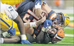  ??  ?? Syracuse’s Tommy DeVito, bottom, is sacked by Pittsburgh’s Deslin Alexandre during the Oct. 18 game in Syracuse, N.Y.