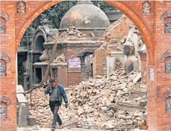  ?? FOTO: AP ?? Weinend läuft ein Mann durch die Trümmer der Stadt Bhaktapur nahe Kathmandu. Bei dem schweren Beben wurden nicht nur Häuser, sondern auch zahlreiche Kulturdenk­mäler zerstört.