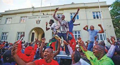  ?? AP ?? Zimbabwean­s celebrate outside the parliament building immediatel­y after hearing the news that President Robert Mugabe had resigned, in downtown Harare yesterday. Mugabe had refused to step down even after being expelled on Sunday from his party.