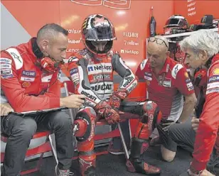  ?? // DUCATI ?? Jorge Lorenzo, rodeado de su equipo en el box, solo pudo completar una vuelta a Motegi antes de renunciar definitiva­mente a correr el GP de Japón