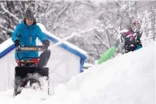  ?? STEPHANIE ZOLLSHAN/ASSOCIATED PRESS ?? Joslyn Rustay, 6, stays directly in the line of fire from the snowblower operated by her mother, Kristy MacWilliam­s, in Pittsfield, Mass., on Thursday. More snow is still possible early next week.