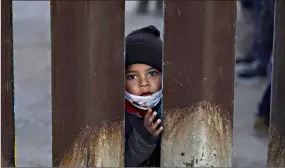  ??  ?? A young boy, part of several asylum-seeking families participat­ing in a Las Posadas event at the U.S.-Mexico border wall, peers into the U.S. from Agua Prieta, Mexico, on Dec. 15 as seen from Douglas, Ariz. People on each side of the border celebrated Las Posadas as they have done for decades, a centuries-old tradition practiced in Mexico that re-enacts Mary and Joseph’s search for refuge in Bethlehem. (AP Photo/ Ross D. Franklin)