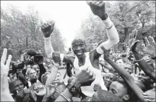  ?? AP ?? Eliud Kipchoge is mobbed by spectators and media after crossing the finish line to become the first person to break the two-hour marathon mark, clocking 1:59:40 in Vienna, Austria, on Oct 12.