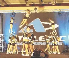  ?? CONTRIBUTE­D PHOTO ?? Four fliers are tossed into the air during a cheer routine at the 2017 Athletic Championsh­ips.