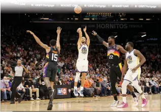  ?? Christian Petersen
/ Getty Images /TNS ?? The Golden State Warriors’ Stephen Curry (30) attempts a 3-point shot over the Phoenix Suns’ Cameron Payne (15) during the first half at Footprint Center ontuesday in Phoenix.
