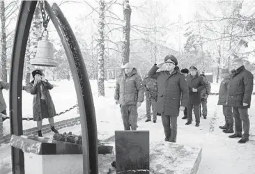  ?? SERGEI GAVRILENKO/AP ?? Kemerovo Governor Sergei Tsivilyov, center left, and Russian Deputy Prosecutor General Dmitrii Demeshin, center, lay flowers Friday at the memorial to honor fallen rescuers in Gramoteino village in Russia. Rescue crews found a survivor in a Siberian coal mine where dozens of miners are presumed dead after an explosion, a senior regional official said Friday.